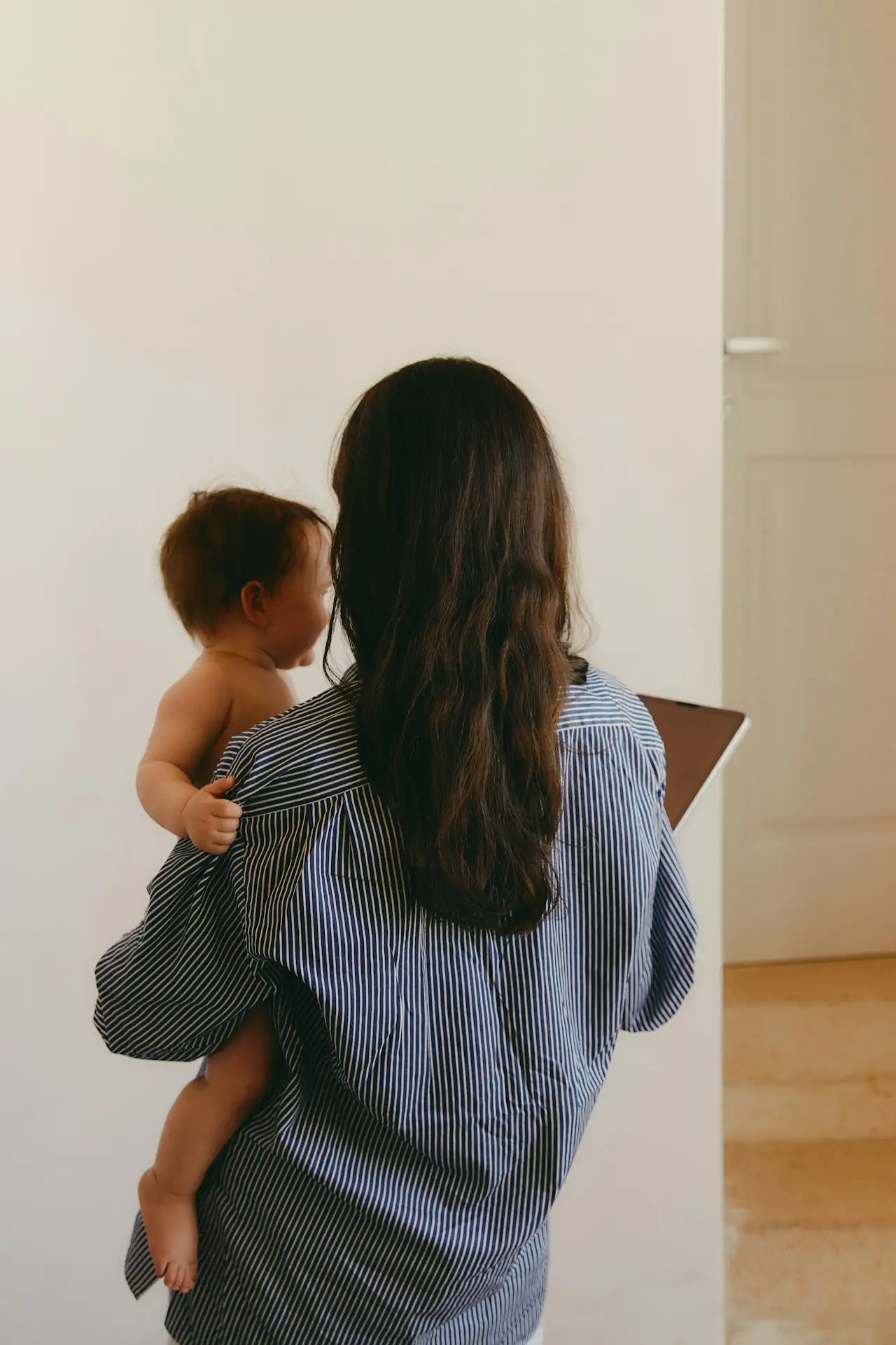 Pflegende Mutter mit Baby am Arm