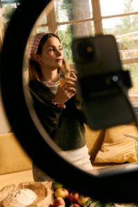 Influencerin vor ihrem aufgebauten Ringlicht und Handy